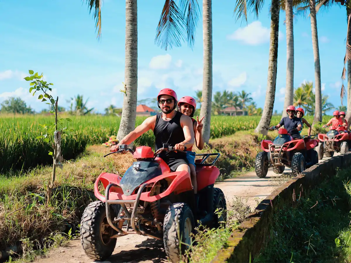 Riders splashing an ATV through a muddy jungle track near Ubud