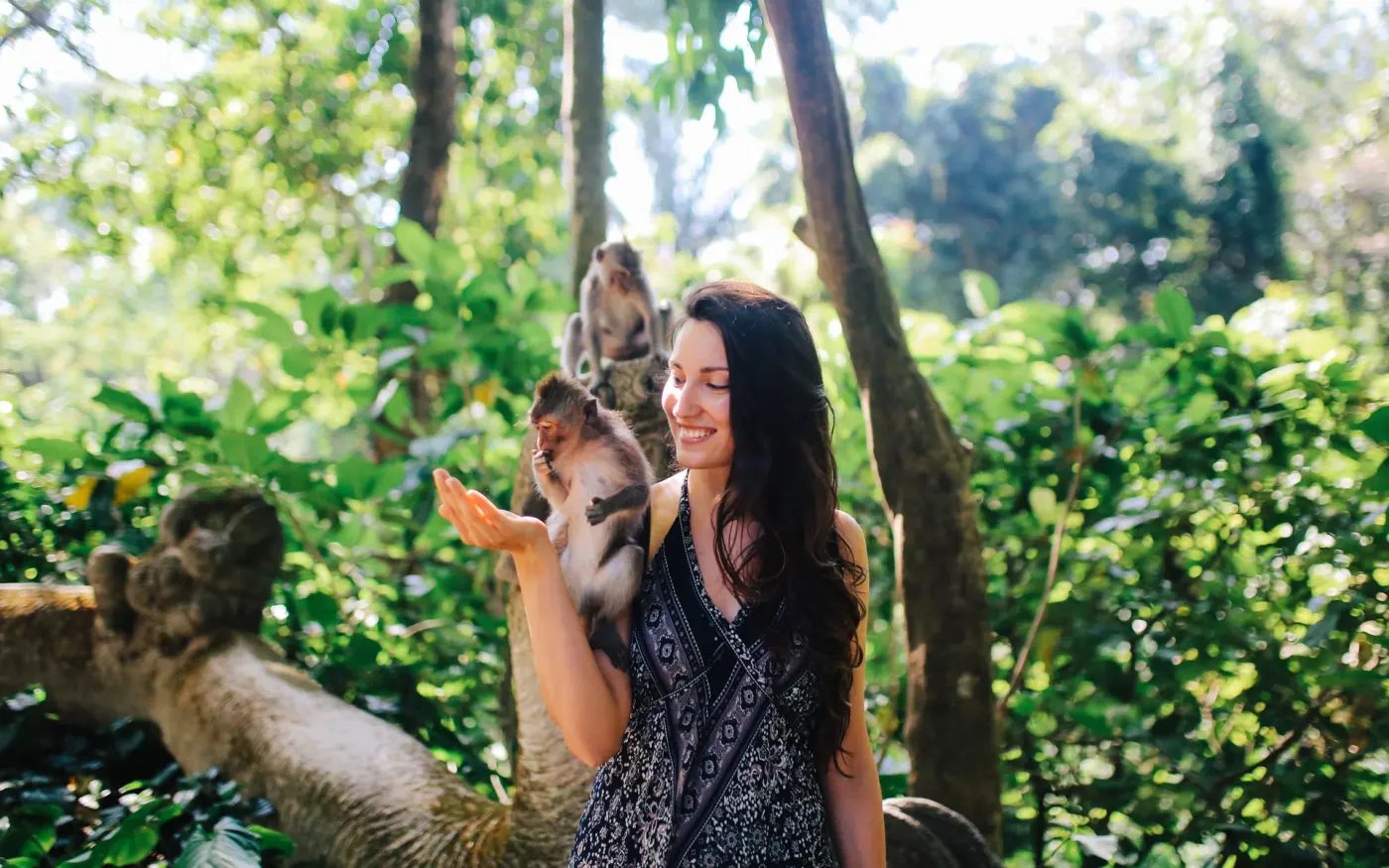 A visitor among the macaques in a Bali monkey forest